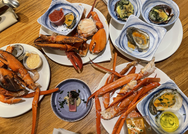 Plates of seafood - crab legs, lobster, and oysters