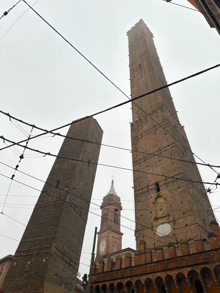 One tall tower and one half it's size, both slightly leaning