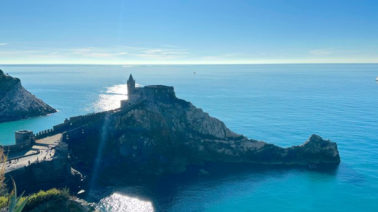 View of a church on a hill with water below and surrounding it