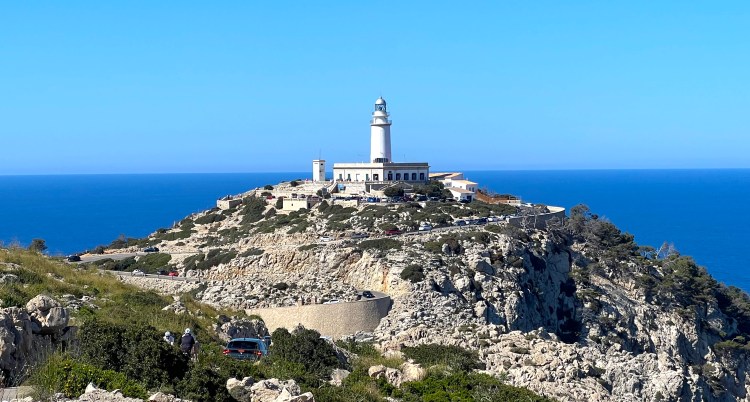 View of lighthouse at top of cliff in distance