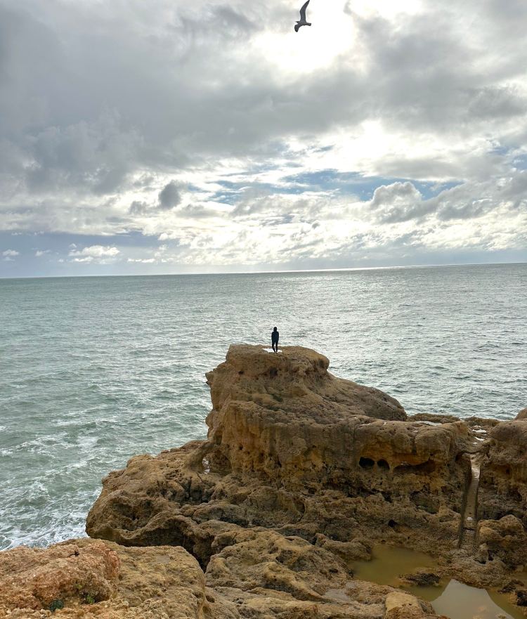 Standing on top of rock near the coast at A Pedra de Turok
