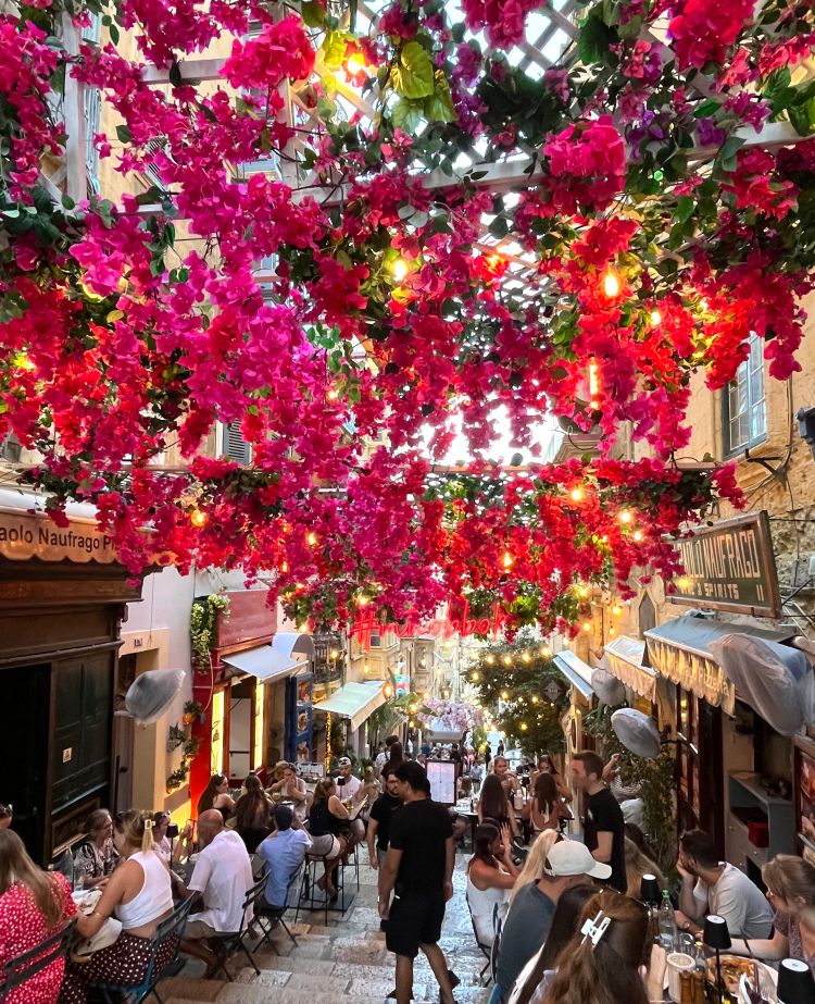 Street view of San Paolo Naufrago, with floral decorations draped across the top